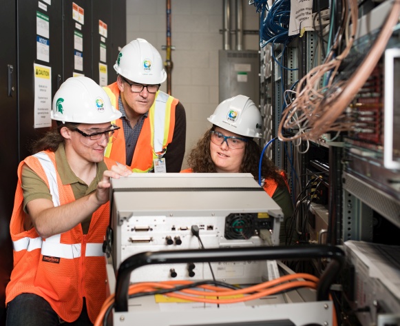 Graduate student Christopher Richard (left) works with FRIB scientists and faculty on modern electronic instrumentation to measure critical parameters of the high power ion beam.