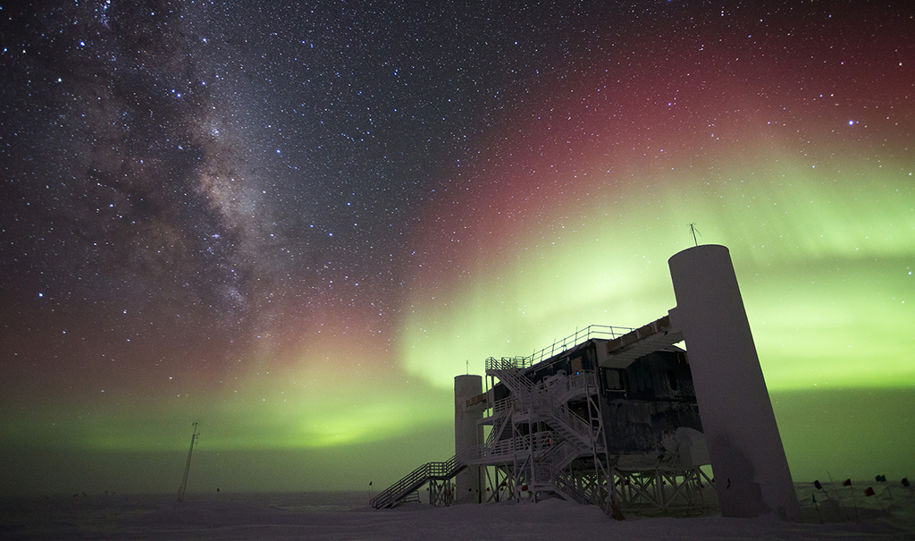 The IceCube Neutrino Observatory encompasses a cubic kilometer of ice under the surface of the Antarctic icecap at the South Pole. This is a photo of the laboratory building at the surface on a winter night with auroral activity.