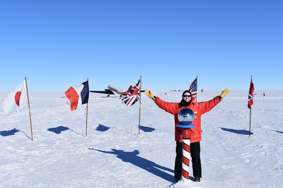 Rysewyk at the ceremonial South Pole with a Basler plane in the background. The location of the ceremonial South Pole stays the same; however, the geographical South Pole moves a little bit every year. In 2018, it moved 33 feet!